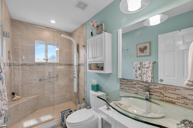 bathroom featuring vanity, toilet, an enclosed shower, and decorative backsplash