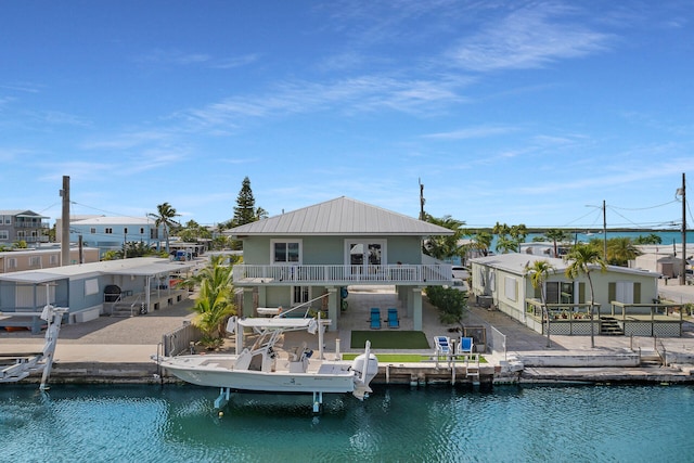 59 Bird Ln, Key Largo, FL 33037 - back of property featuring fence, stucco siding, a water view, a patio, and metal roof