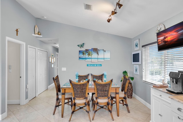 tiled dining space featuring lofted ceiling