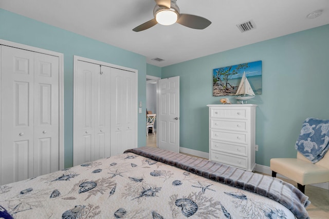 bedroom featuring ceiling fan and two closets