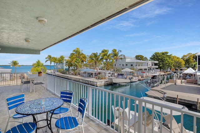 balcony with a water view and a boat dock