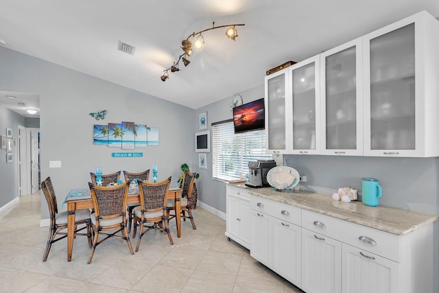 dining area with light tile patterned flooring and rail lighting