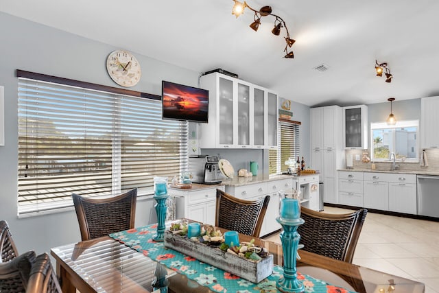 dining area featuring sink and light tile patterned floors