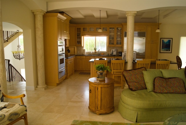 living room with sink and decorative columns