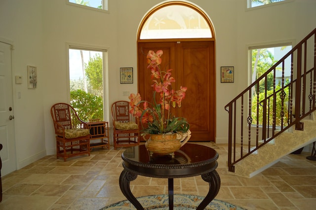 foyer featuring plenty of natural light and a towering ceiling