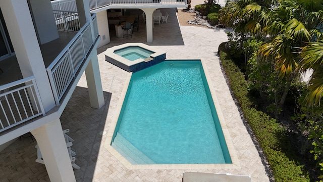 view of swimming pool featuring an in ground hot tub, exterior bar, and a patio