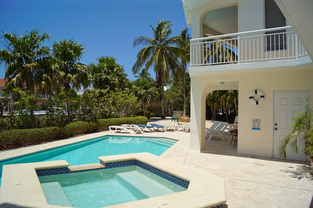 view of swimming pool with an in ground hot tub and a patio