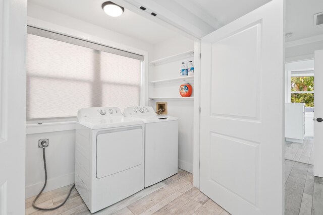 washroom with separate washer and dryer and light hardwood / wood-style flooring