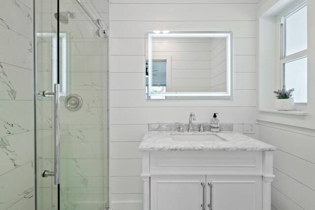 bathroom featuring vanity and a shower with shower door