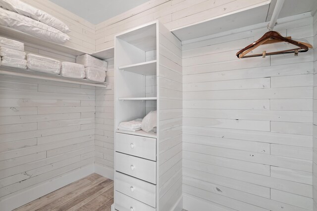 walk in closet with light hardwood / wood-style flooring