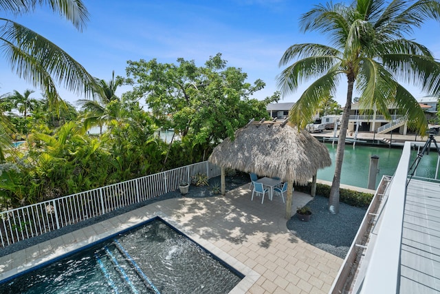 view of swimming pool featuring a water view, a patio area, and a gazebo