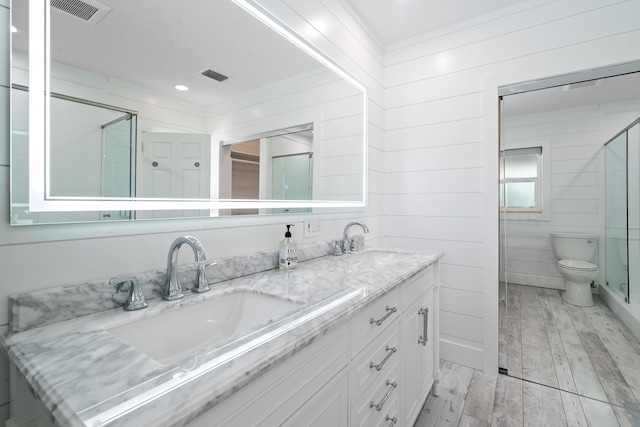 bathroom with vanity, wood-type flooring, ornamental molding, and toilet