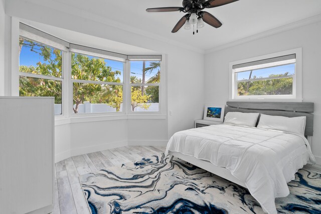 bedroom featuring crown molding, ceiling fan, and wood-type flooring