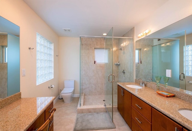 bathroom featuring vanity, tile patterned flooring, a shower with shower door, and toilet