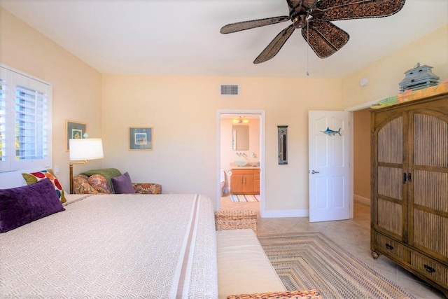 bedroom with ensuite bathroom, light tile patterned floors, and ceiling fan