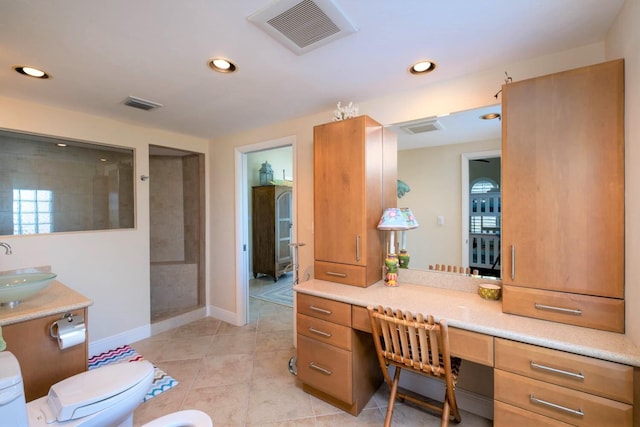 bathroom with a tile shower, vanity, toilet, a bidet, and tile patterned floors