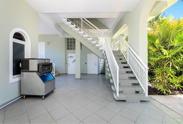 stairs with tile patterned flooring and a high ceiling