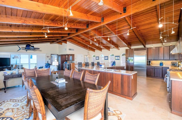 dining space with lofted ceiling with beams, sink, track lighting, and wood ceiling