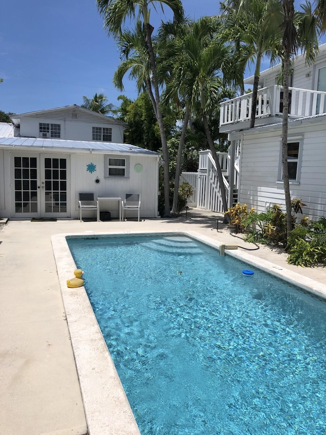 pool with french doors and a patio area