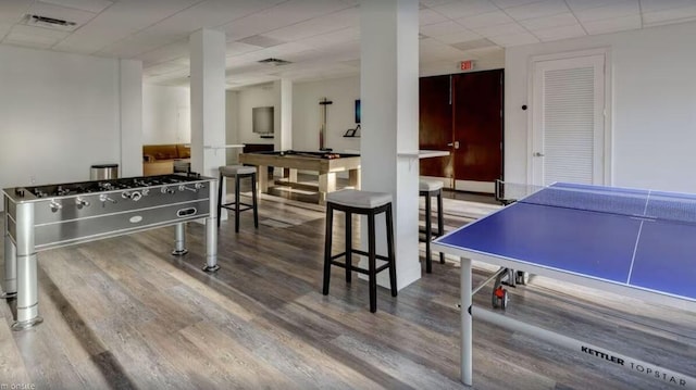 game room featuring hardwood / wood-style floors and a paneled ceiling