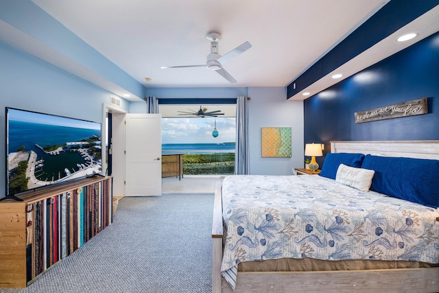 carpeted bedroom featuring access to exterior, ceiling fan, and a water view