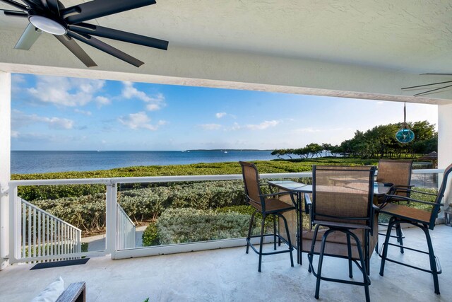 balcony with a water view and ceiling fan