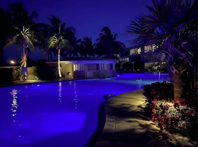 view of pool at twilight