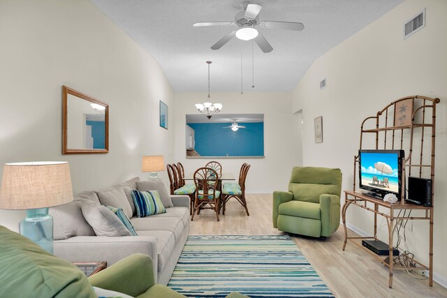 living room featuring ceiling fan with notable chandelier and light hardwood / wood-style floors