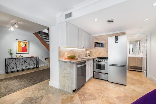 kitchen featuring sink, crown molding, stainless steel appliances, decorative backsplash, and white cabinets