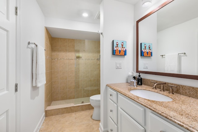 bathroom with tile patterned floors, vanity, toilet, and a tile shower