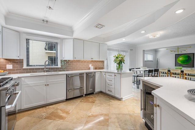 kitchen with white cabinetry, crown molding, and sink