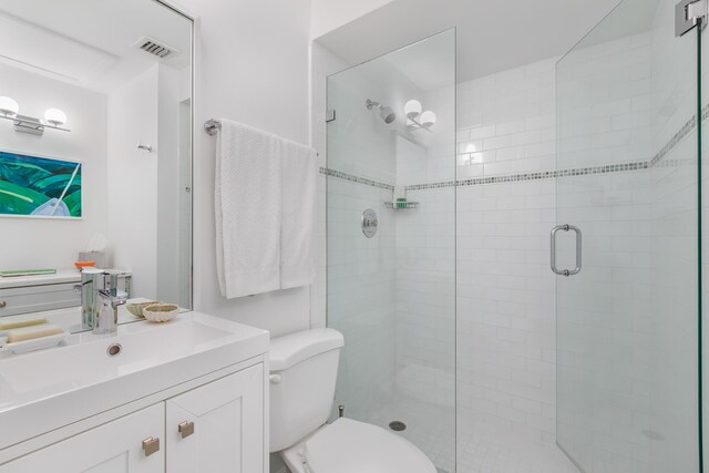 bathroom featuring vanity, toilet, and walk in shower