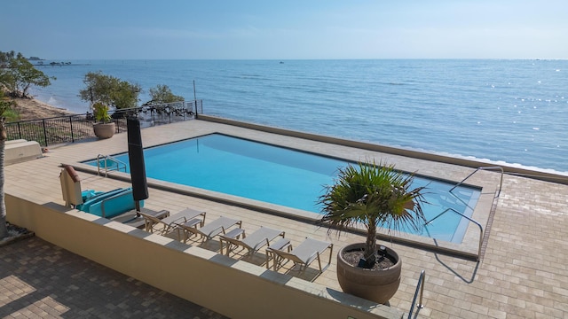 view of pool with a patio area and a water view