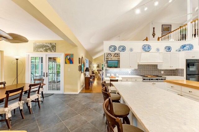 33 Pen Key Dr, Islamorada, FL 33036 - kitchen featuring french doors, double oven, custom range hood, white cabinets, and backsplash