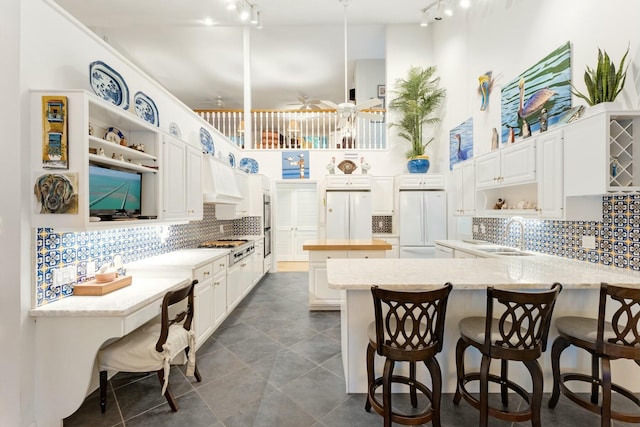 33 Pen Key Dr, Islamorada, FL 33036 - kitchen with stainless steel appliances, white cabinets, a kitchen breakfast bar, and kitchen peninsula