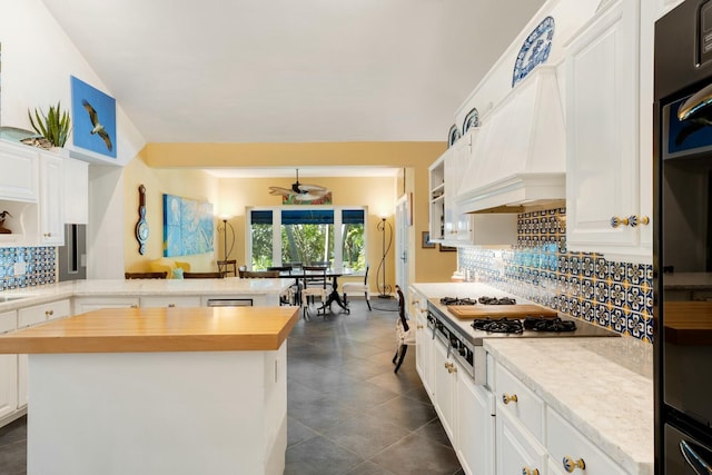 33 Pen Key Dr, Islamorada, FL 33036 - kitchen featuring white cabinetry, wooden counters, backsplash, a center island, and kitchen peninsula