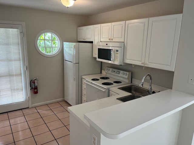 8 Kestral Way, Key West, FL 33040 - kitchen with white appliances, a peninsula, light countertops, and white cabinetry