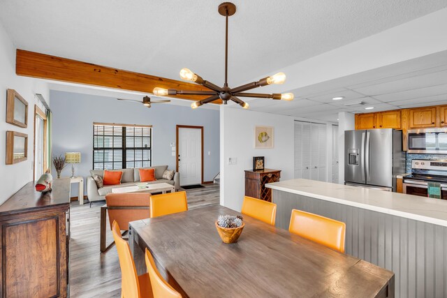 dining area featuring beamed ceiling and light hardwood / wood-style floors