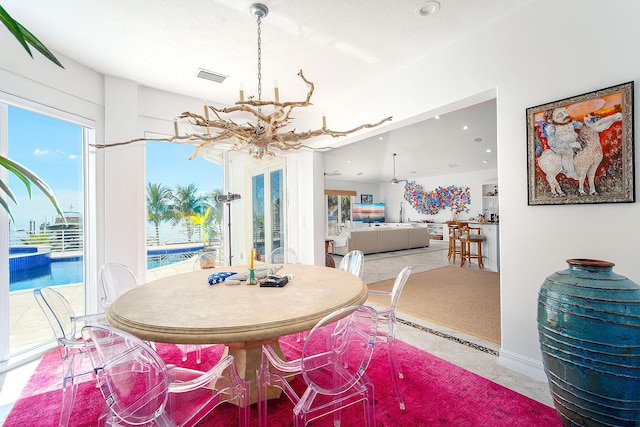 dining space with light tile patterned flooring, a textured ceiling, and a chandelier