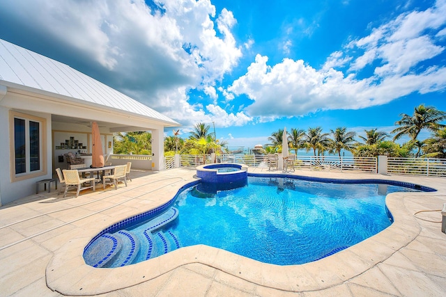 view of swimming pool featuring an in ground hot tub, a water view, and a patio