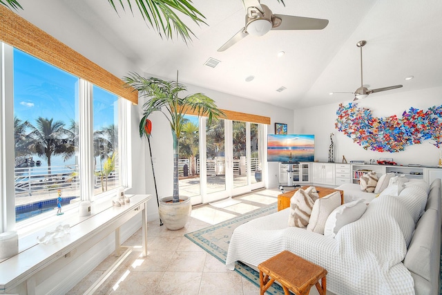 living room featuring vaulted ceiling, ceiling fan, and a water view