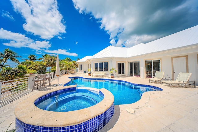 view of pool featuring a patio area and an in ground hot tub