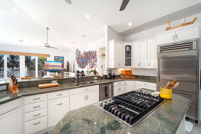 kitchen featuring sink, white cabinetry, vaulted ceiling, appliances with stainless steel finishes, and ceiling fan