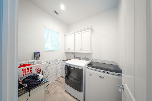 washroom featuring cabinets, light tile patterned floors, and independent washer and dryer