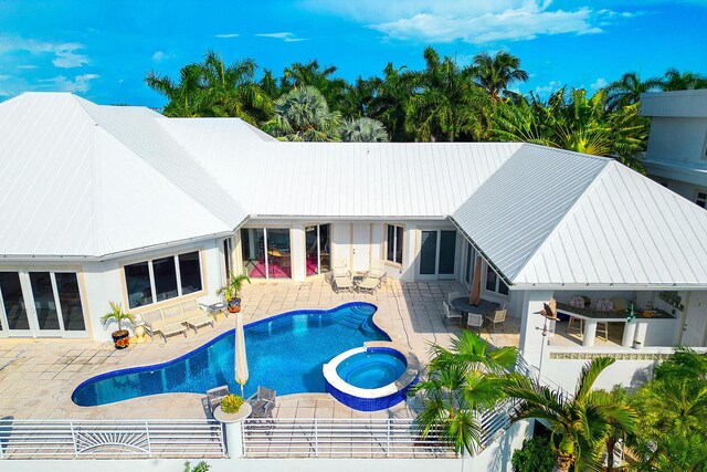 view of swimming pool featuring an in ground hot tub and a patio