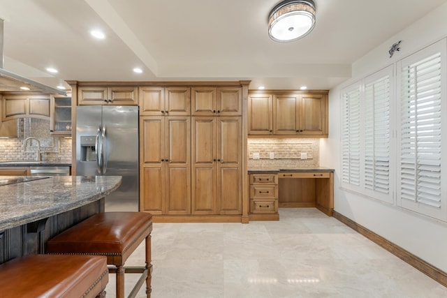 kitchen featuring stainless steel appliances, sink, decorative backsplash, and dark stone countertops