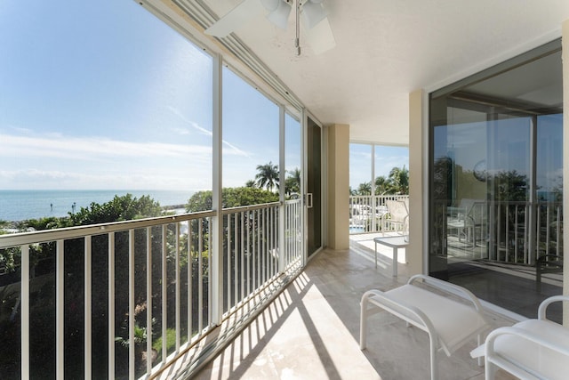 balcony featuring a water view and ceiling fan