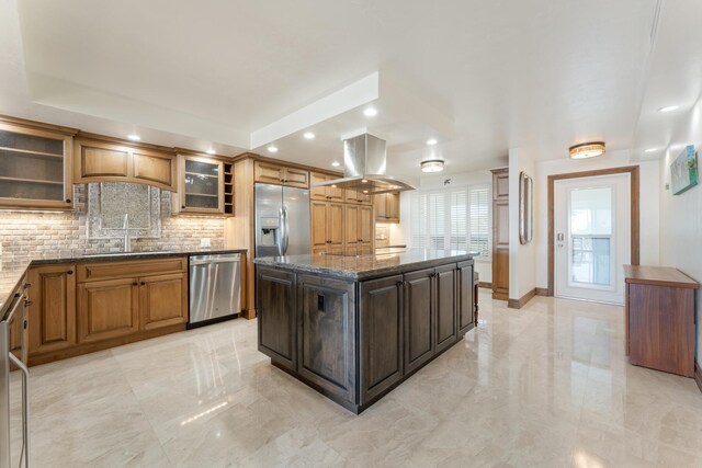 kitchen with sink, island range hood, appliances with stainless steel finishes, a kitchen island, and decorative backsplash