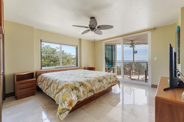 bedroom with multiple windows, ceiling fan, access to outside, and a wall of windows