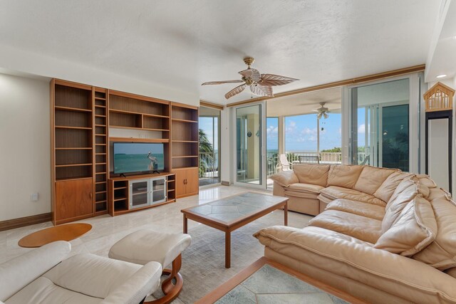 living room featuring ceiling fan, a textured ceiling, and a wall of windows